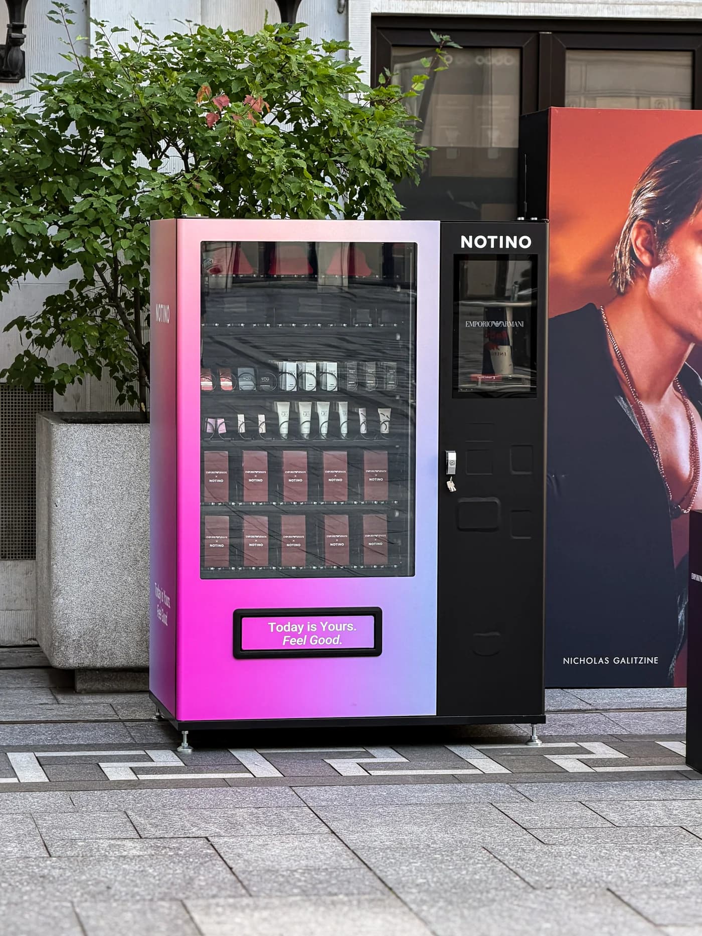Ružový automat Notino s vlastným polepom, obrazovkou a presklenými dverami na evente.
